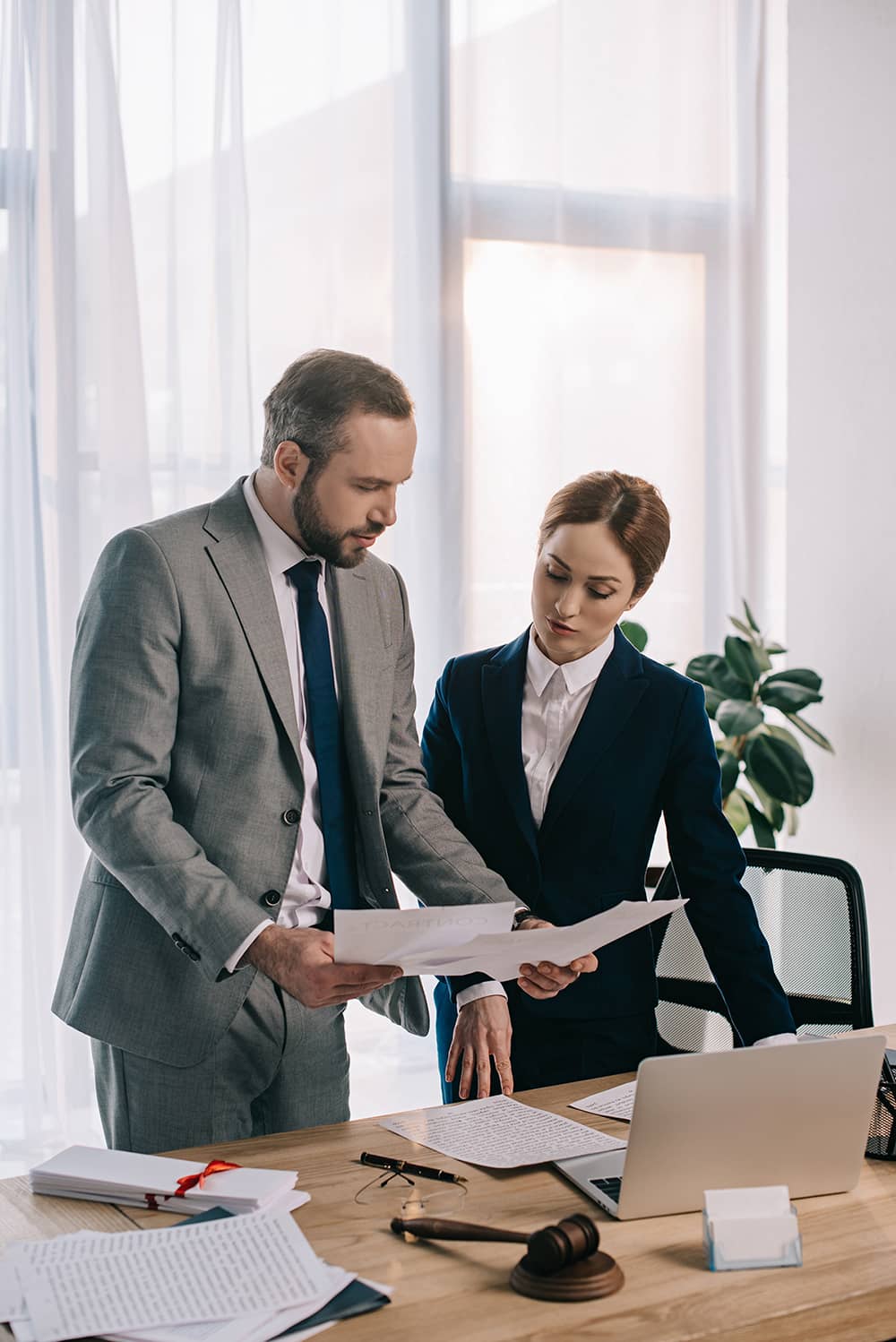 Imagen de dos abogados revisando documentos, representativa del área legal de Eagle Law Firm, enfocado en temas corporativos, mercantiles, marcas, derechos de autor y patentes.